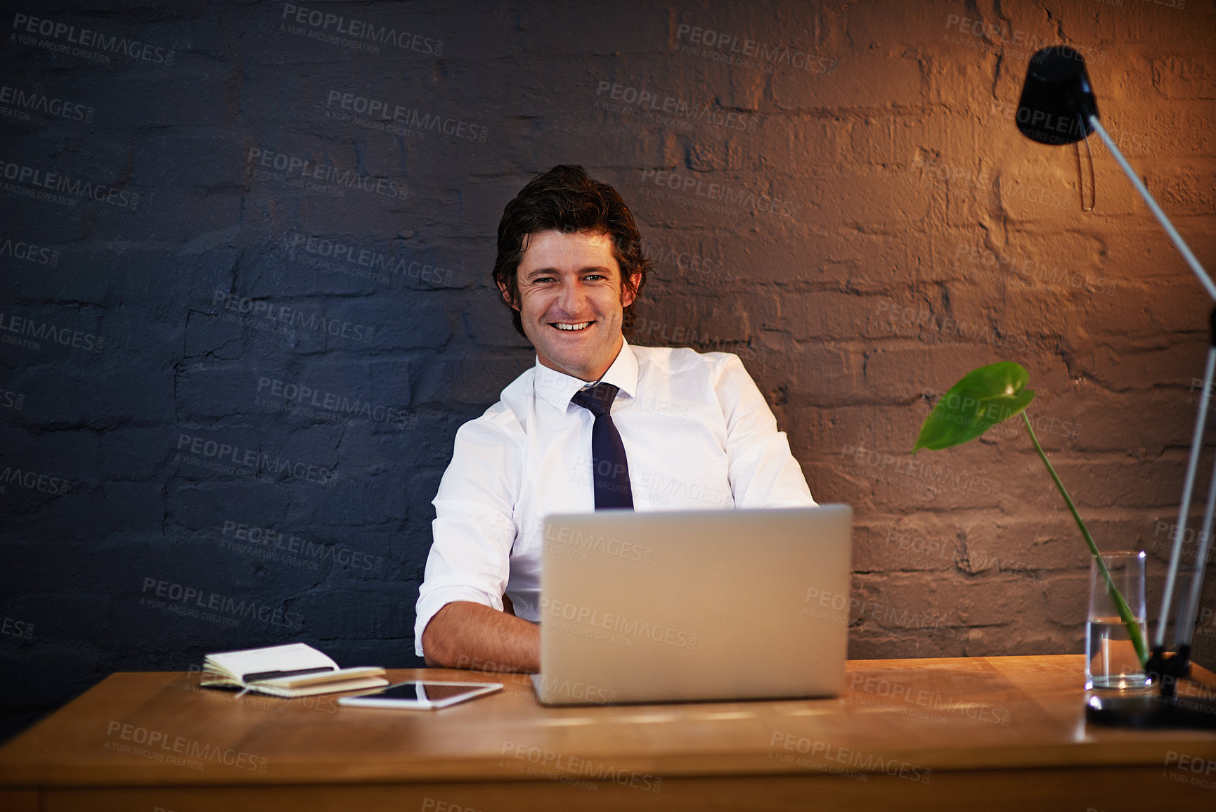 Buy stock photo Businessman, portrait and laptop at desk for reading, online and research for career with pride. Internet, technology and happy male person in office at night with computer for streaming or email   