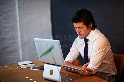 Buy stock photo Shot of a businessman working at his laptop after hours