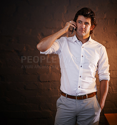 Buy stock photo Cropped shot of a businessman making a phone call after hours