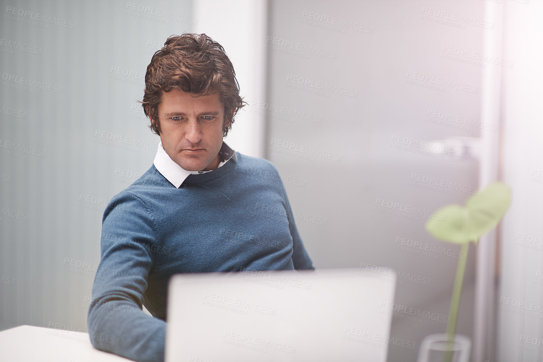 Buy stock photo Cropped shot of a businessman working on a laptop in an office