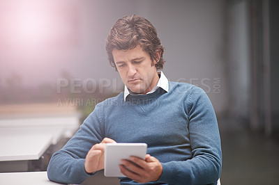 Buy stock photo Cropped shot of a businessman working on a digital tablet in an office