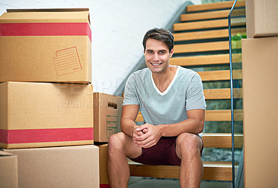 Buy stock photo Portrait of a young man sitting in his new home surrounded by cardboard boxes