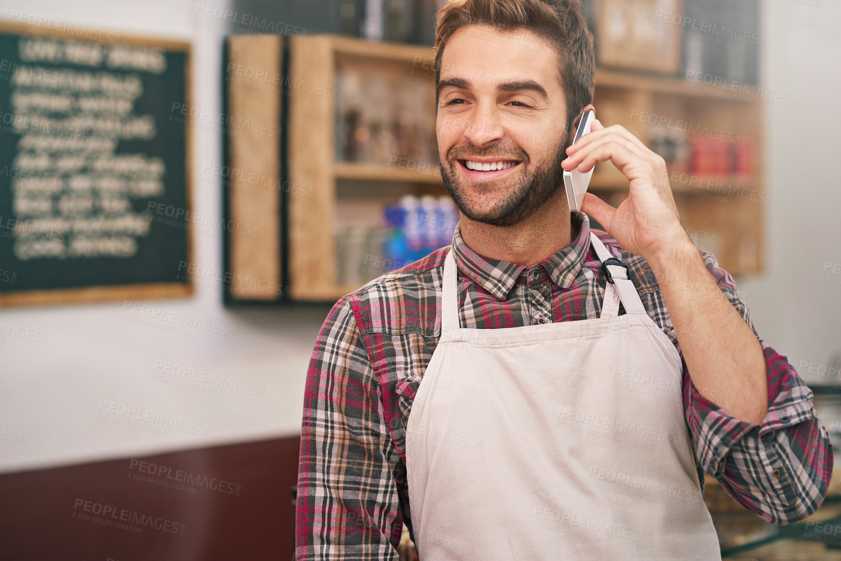 Buy stock photo Man, barista and happy for phone call in a coffee shop to talk to contact for drink order at small business. Person, waiter and smartphone to listening with chat, networking and smile in a cafeteria