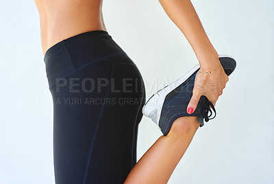 Buy stock photo Cropped shot of a young woman stretching her legs outside