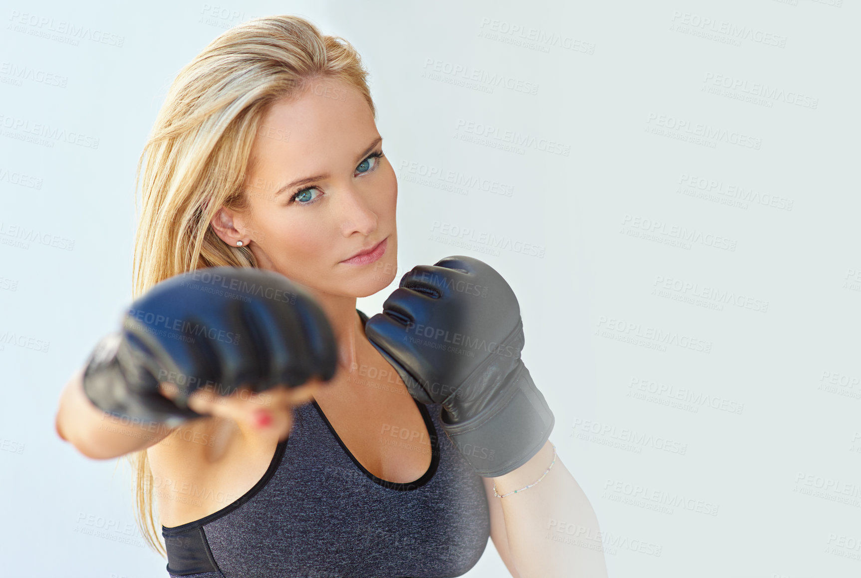 Buy stock photo Shot of a sporty young woman training with mma gloves