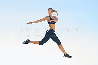 Buy stock photo Full length shot of a sporty young woman jumping against a blue sky