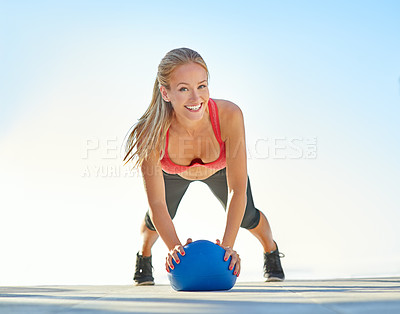 Buy stock photo Full length portrait of a young woman doing pushups with a medicine ball