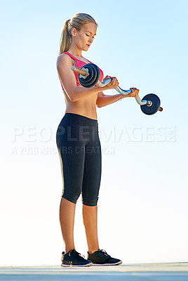 Buy stock photo Full length shot of a young woman working out with a barbell
