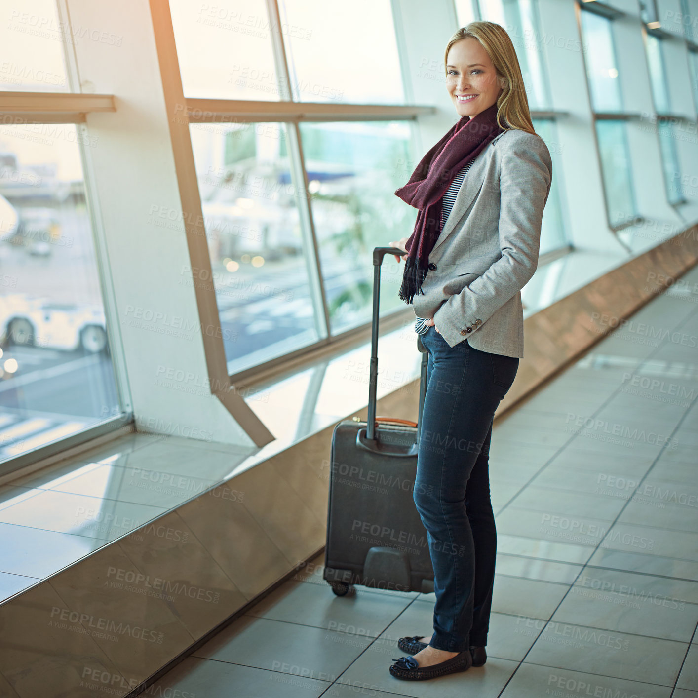 Buy stock photo Portrait of a young woman standing with her luggage in an airport