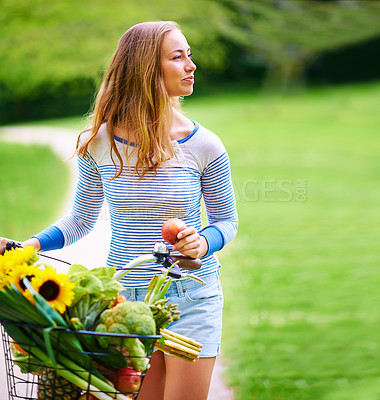 Buy stock photo Shot of a young woman cycling in the park