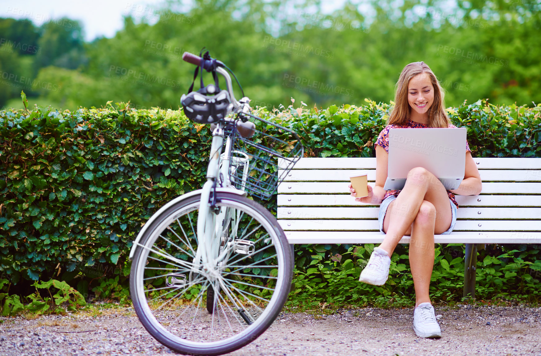 Buy stock photo Laptop, bicycle and happy woman on bench in park with coffee, smile and online connectivity for freelance project. Remote work, relax and girl checking email with bike, computer and drink in nature