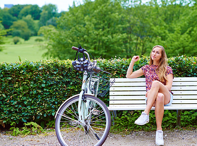 Buy stock photo Woman, nature and bicycle with thinking on vacation, holiday and happiness in park or outdoor. Female person, bench and travel in countryside for rest, relax and break as student on adventure in town