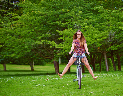 Buy stock photo Shot of a young woman cycling in the park