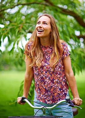 Buy stock photo Shot of a young woman cycling in the park