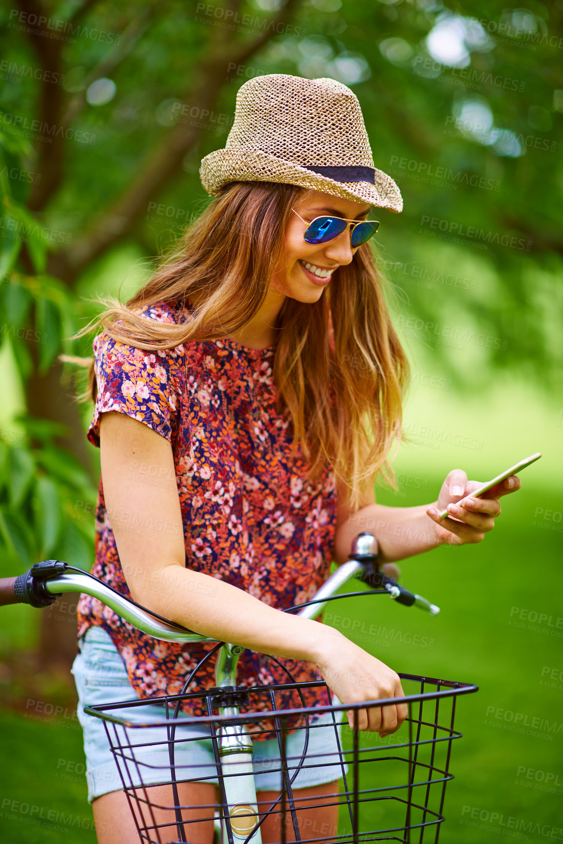 Buy stock photo Woman, bike and smartphone for travel with holiday and adventure outdoor, happy and freedom in nature. Influencer, blog and content creation for park browsing, smile and summer profile picture