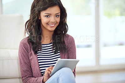 Buy stock photo Portrait of a young woman using her digital tablet while sitting on the floor