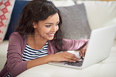 Buy stock photo Shot of a young woman using her laptop while sitting on the floor