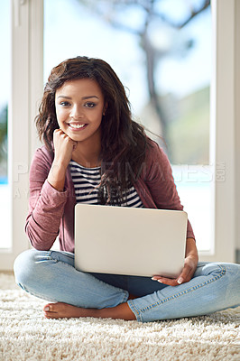 Buy stock photo Portrait of a young woman using her laptop while sitting on the floor
