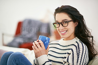 Buy stock photo Shot of a young woman having a cup of coffee while relaxing at home