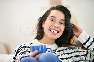 Buy stock photo Shot of a young woman having a cup of coffee while relaxing at home