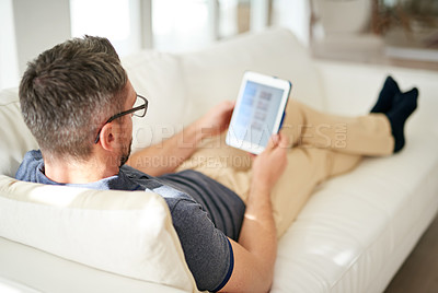 Buy stock photo Man, relax and tablet screen in living room in home for social media, networking and reading news online. House, male person and technology on sofa for connection, watching or browsing for content