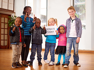 Buy stock photo Shot of a group of children holding up a 'donate today' sign