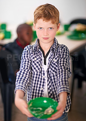 Buy stock photo Shot of a young boy eating at a volunteer run kitchen
