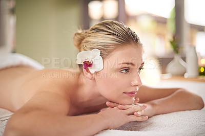 Buy stock photo Shot of a young woman lying on a massage table at the spa