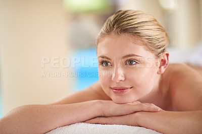 Buy stock photo Shot of a young woman lying on a massage table at the spa