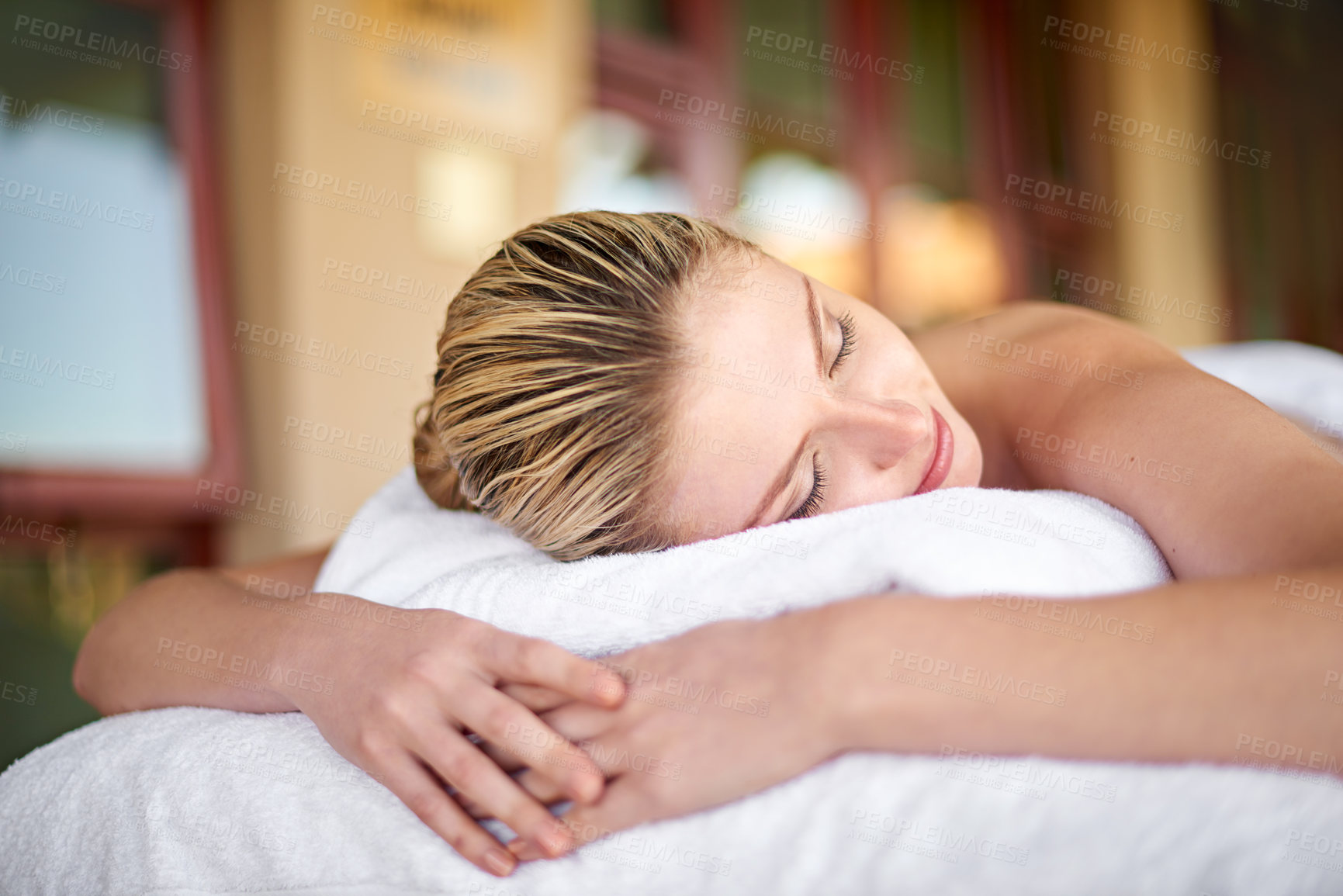 Buy stock photo Shot of a young woman lying on a massage table at the spa