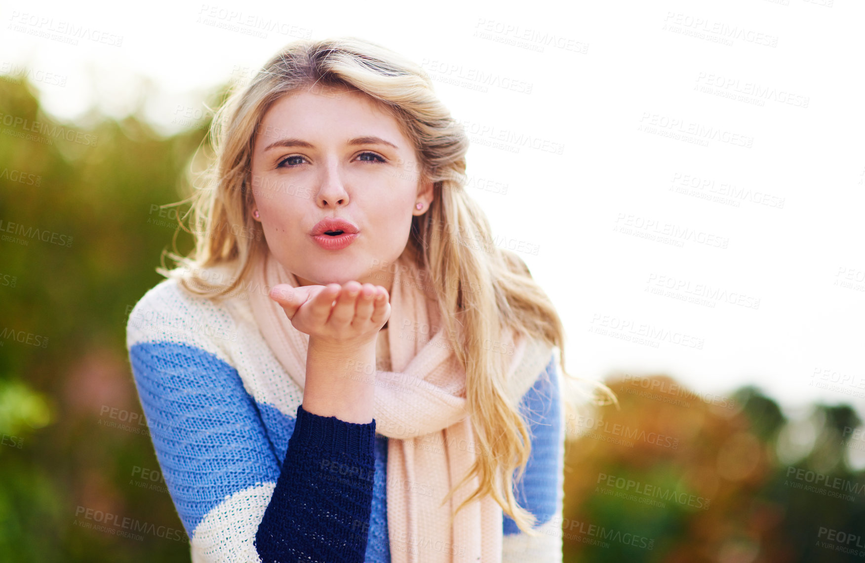 Buy stock photo Girl, blowing and kiss in outdoors with happiness, positive mindset and fun or flirting. Romance, woman and portrait with hand kisses, nature and care for alluring or cute in summer with emoji