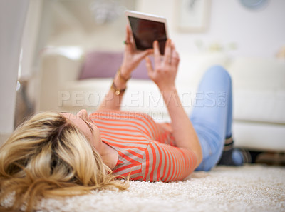 Buy stock photo Full length shot of a young woman using her tablet at home