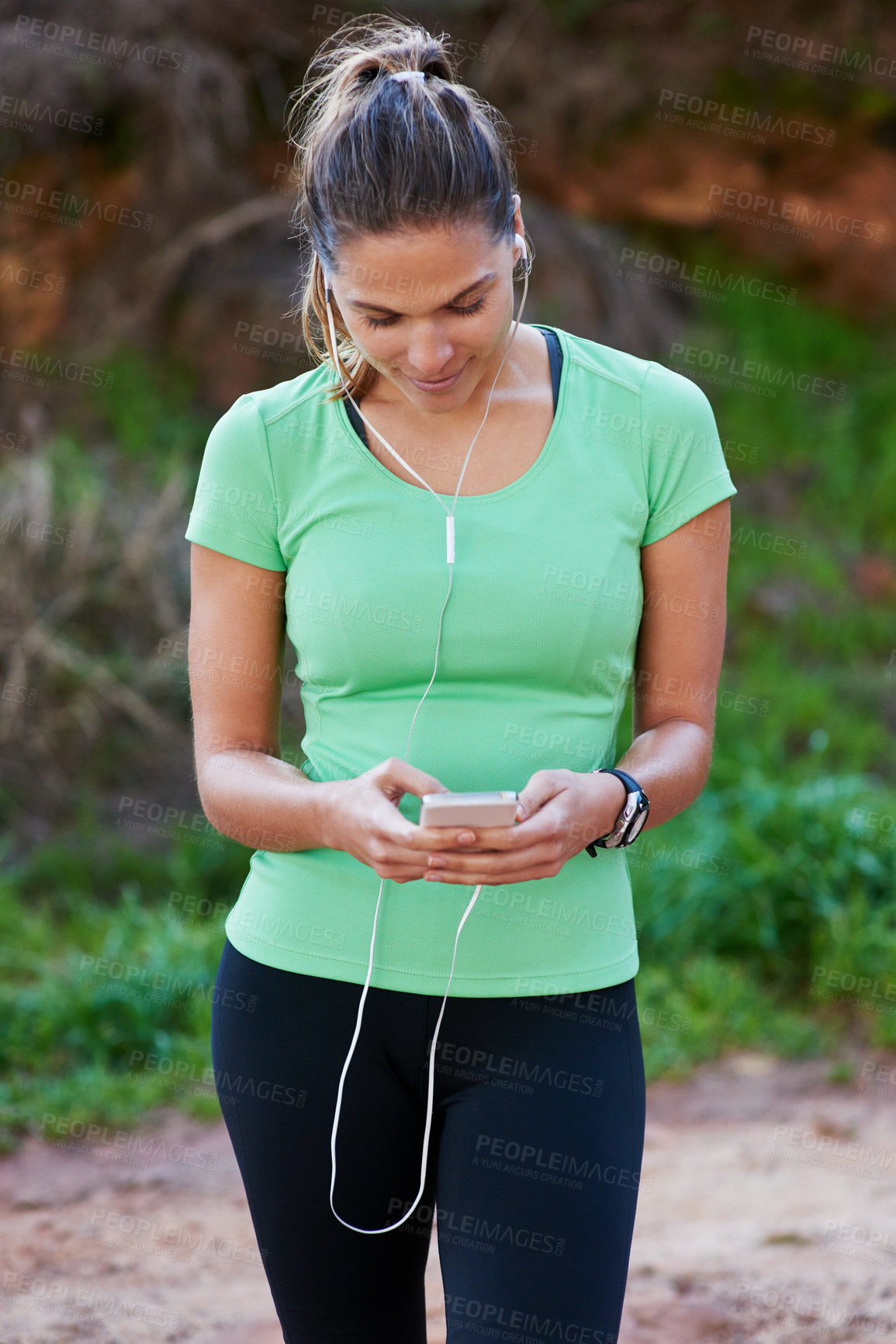 Buy stock photo Woman, fitness and phone for listening to music, exercise and workout outdoor in forest or park with health tracker. Person or runner typing, search or scroll on mobile app for audio and training