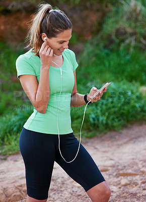 Buy stock photo Outdoor, fitness and woman listening to music on mobile app for exercise, workout and training in forest. Person or runner with smartphone for audio streaming, podcast and health tracker in nature 