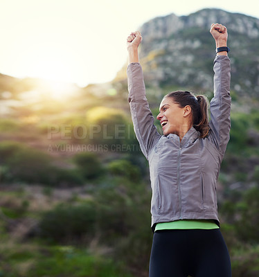 Buy stock photo Shot of a young woman with her arms raised in vicotry while out for a trail run