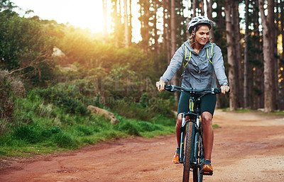 Buy stock photo Shot of a female mountain biker out for an early morning ride