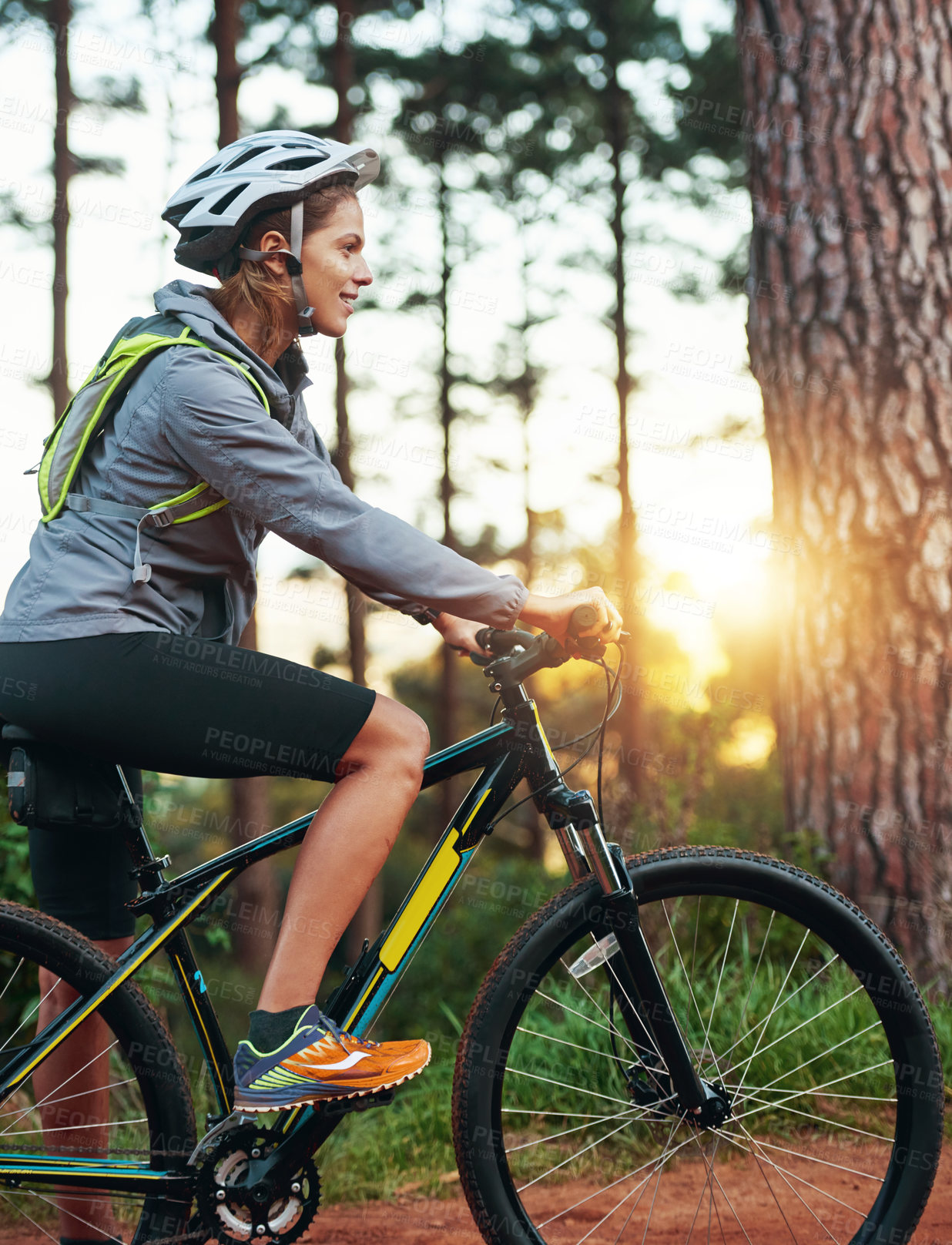 Buy stock photo Woman, bicycle and forest in sunrise, cycling and outdoor for fitness, training and riding. Cardio , helmet and morning in athlete, trees and sport for wellness, woods and trail or nature, energy