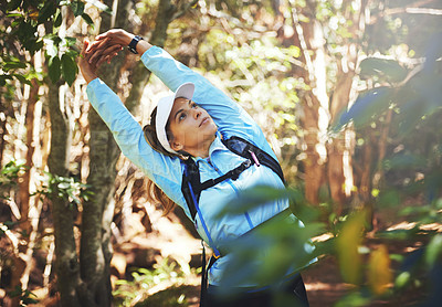 Buy stock photo Shot of a young woman warming up for a trail run