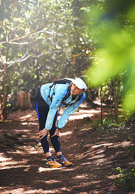 Buy stock photo Break, runner and tired woman hiking in nature on trail or outdoor adventure to explore on holiday vacation. Girl, rest or hiker trekking in woods for running training, fitness or travel with fatigue