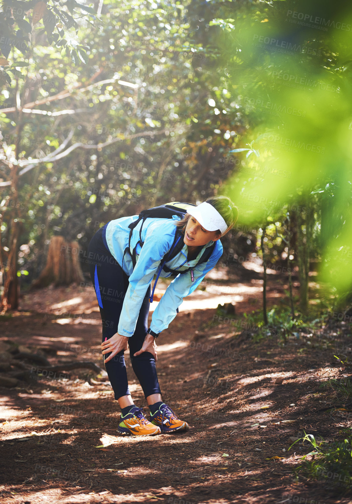 Buy stock photo Break, runner and tired woman hiking in nature on trail or outdoor adventure to explore on holiday vacation. Girl, rest or hiker trekking in woods for running training, fitness or travel with fatigue