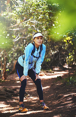 Buy stock photo Tired, runner and woman hiking in nature on trail or outdoor adventure to explore on holiday vacation. Girl, rest break or hiker trekking in woods for running training, fitness or travel with fatigue