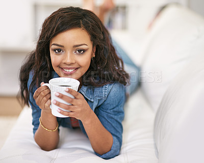Buy stock photo Portrait, coffee and relax with woman on sofa in living room of home for morning or weekend time off. Smile, beverage or drink with happy young person lying on couch in apartment for wellness