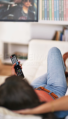 Buy stock photo Shot of a young woman watching television at home