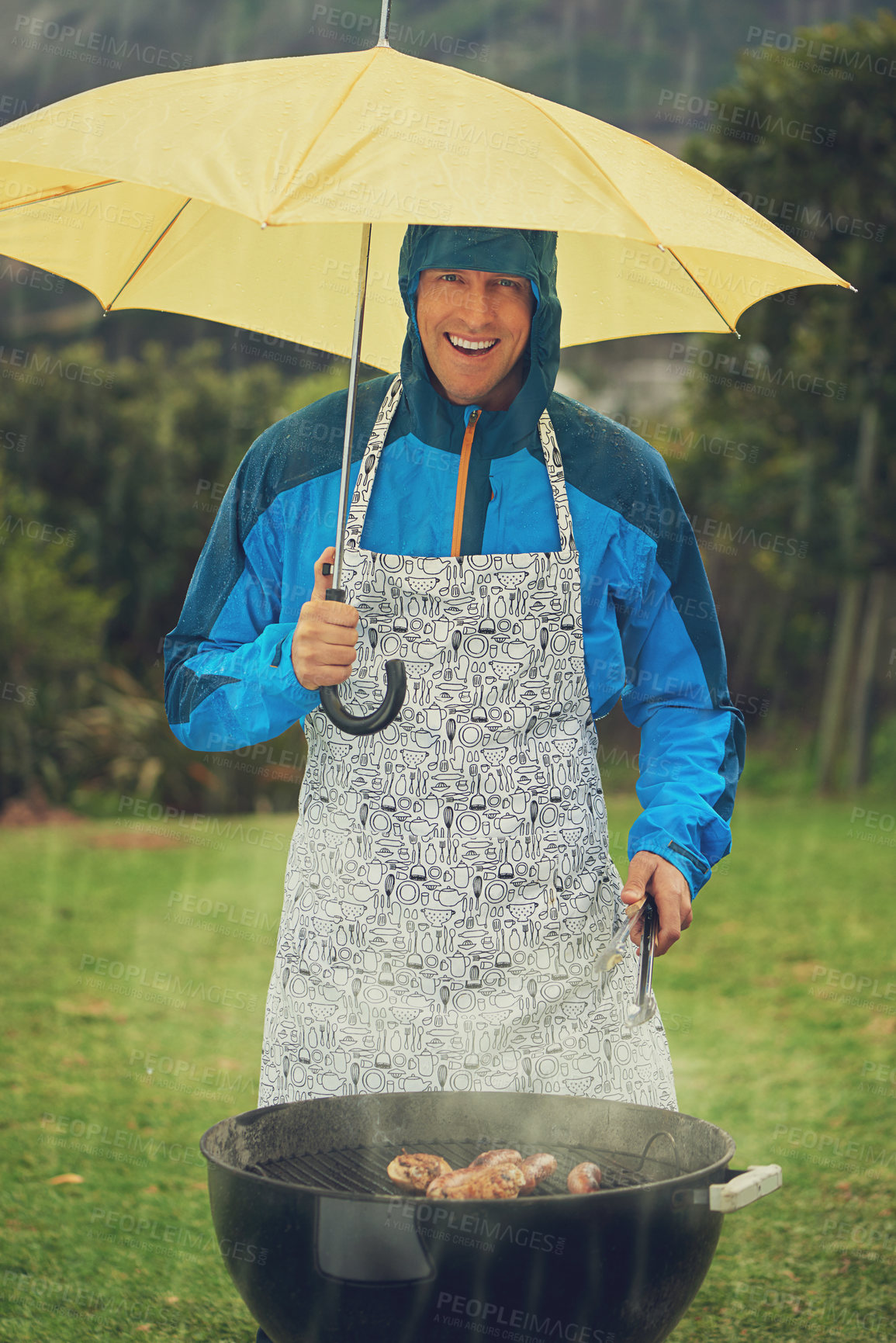 Buy stock photo Happy man, portrait and umbrella in rain for barbecue meal, supper or dinner on the fire grill. Male person smiling for insurance, cover or protection while cooking under raining or stormy weather
