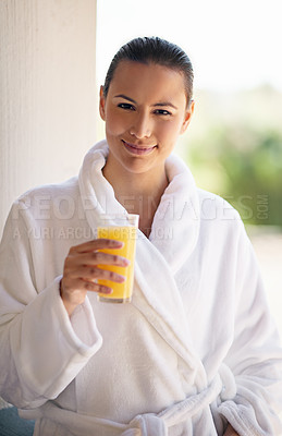 Buy stock photo Shot of a young woman drinking a glass of orange juice at the day spa