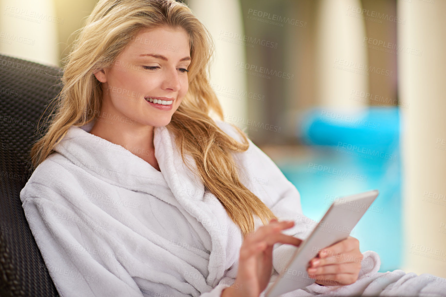 Buy stock photo Shot of a young woman relaxing with her digital tablet at a day spa