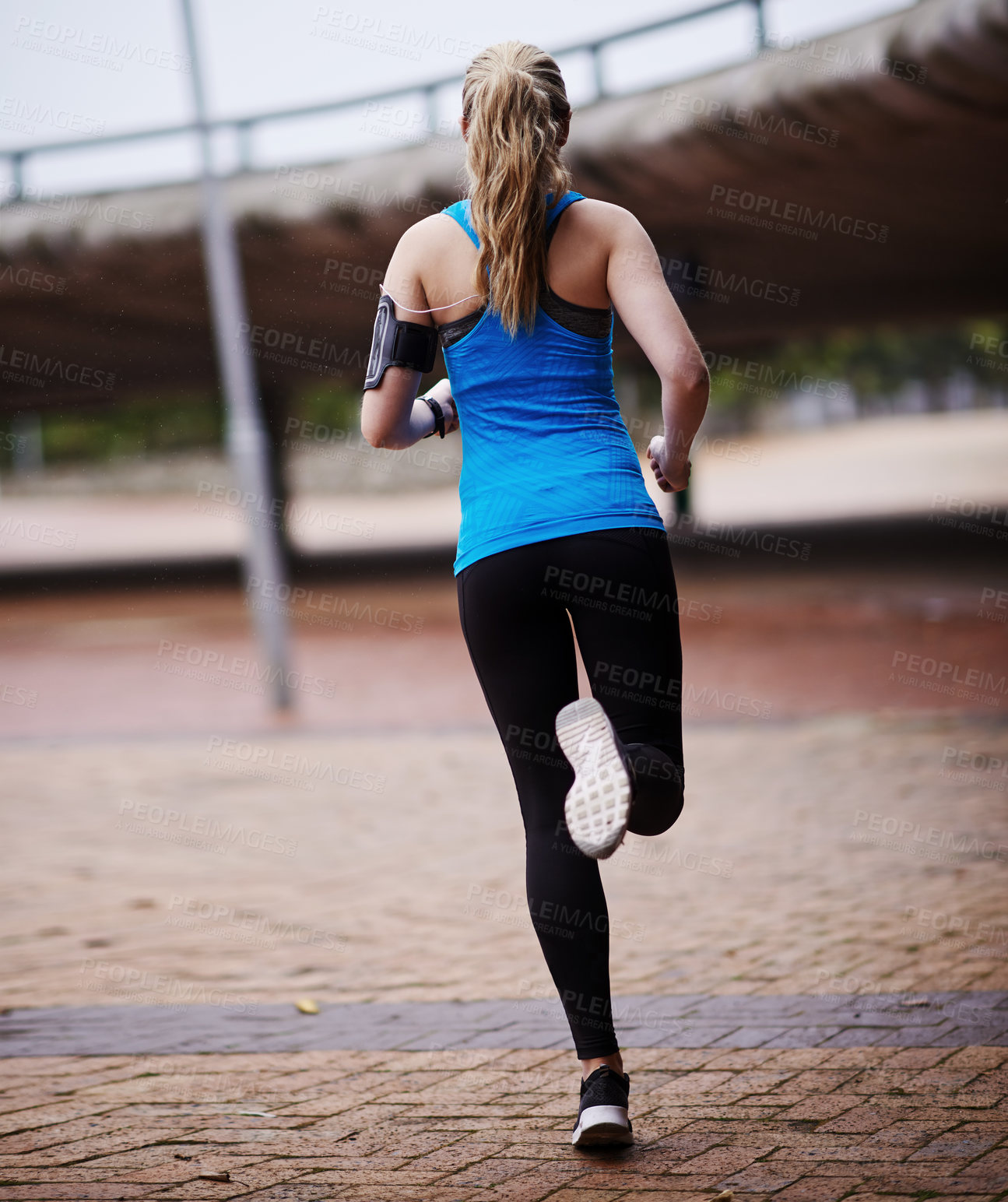 Buy stock photo Rearview shot of a young woman out running