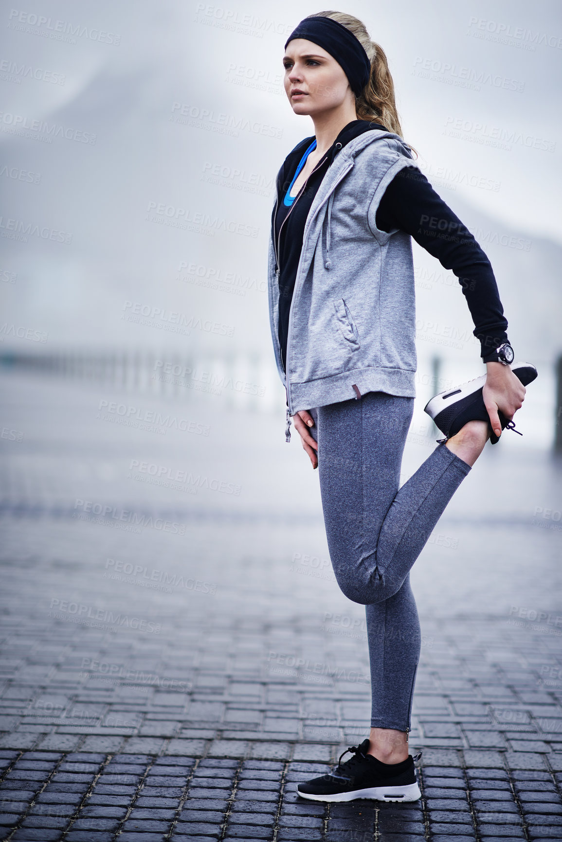 Buy stock photo Shot of a young woman stretching her legs before a run