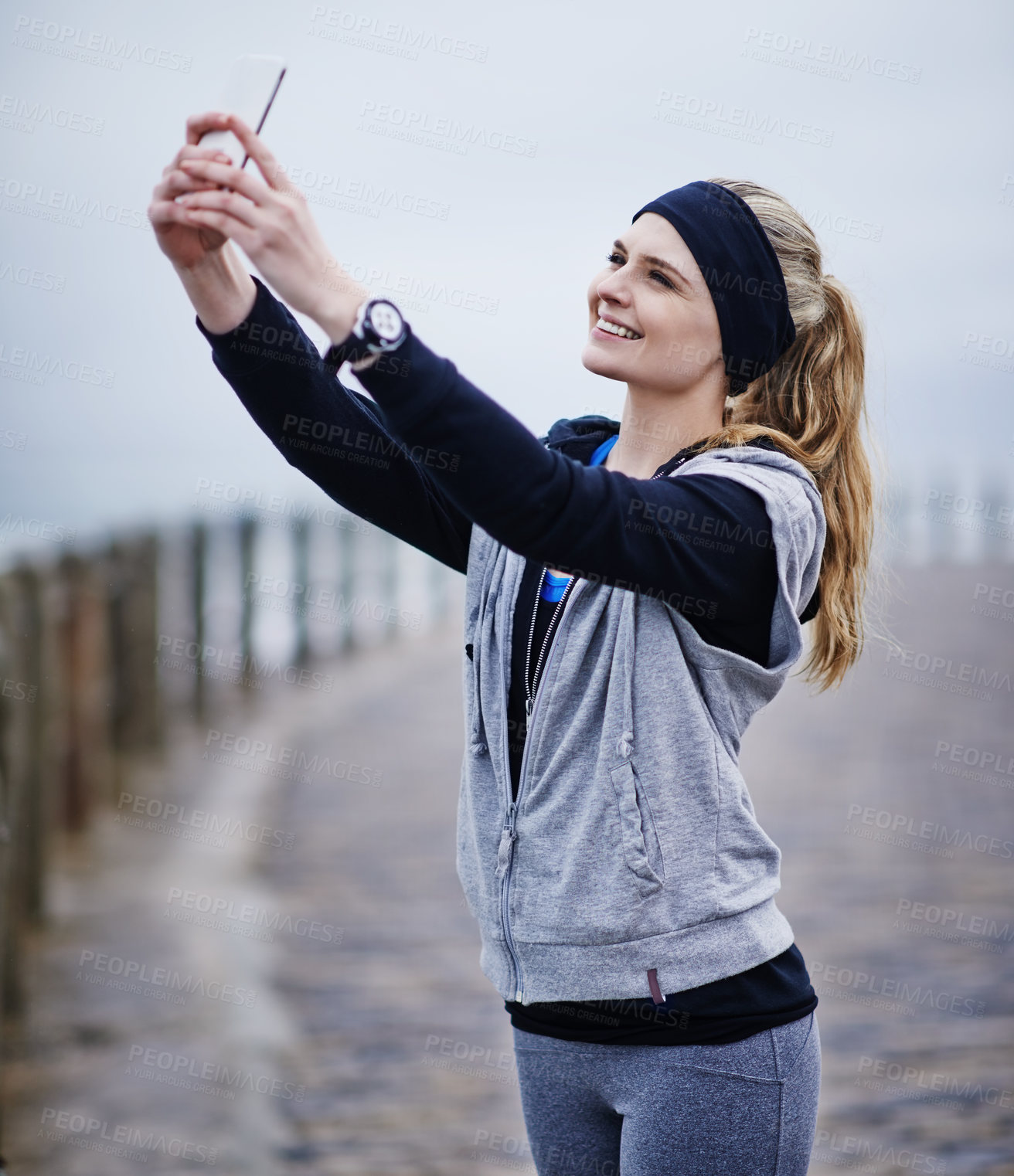 Buy stock photo Shot of a young woman taking a selfie while exercising outdoors