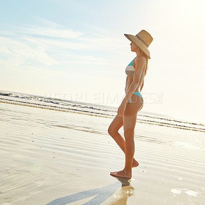 Buy stock photo Shot of an attractive young woman walking on the beach